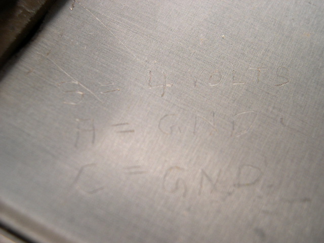 Someone etched in the corresponding voltage for the plugs.